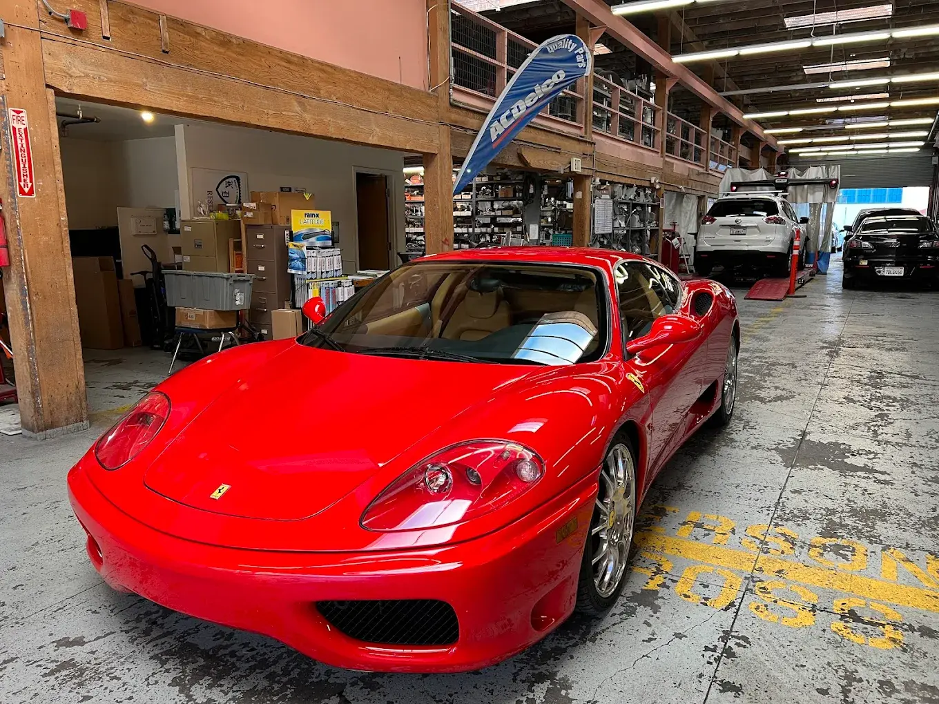 A glossy red sports car parked in the service area at Auto City Repair in San Francisco