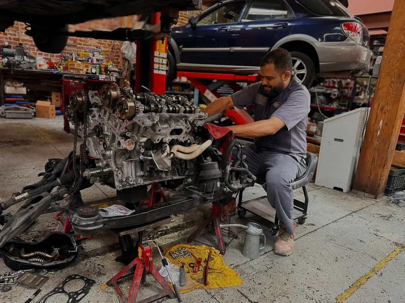 Technician working on an engine in the service bay at Auto City Repair in San Francisco